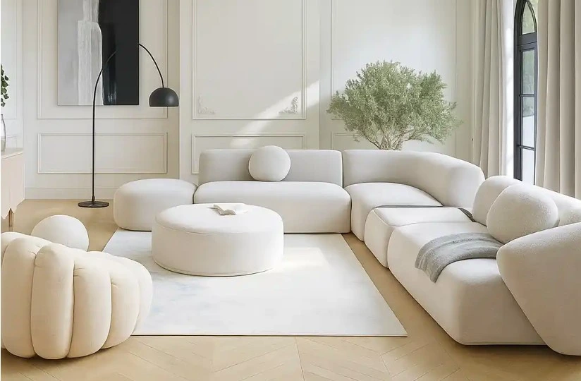 A luxurious, curved modular sofa in off-white boucle fabric with a large round ottoman and accent chair.