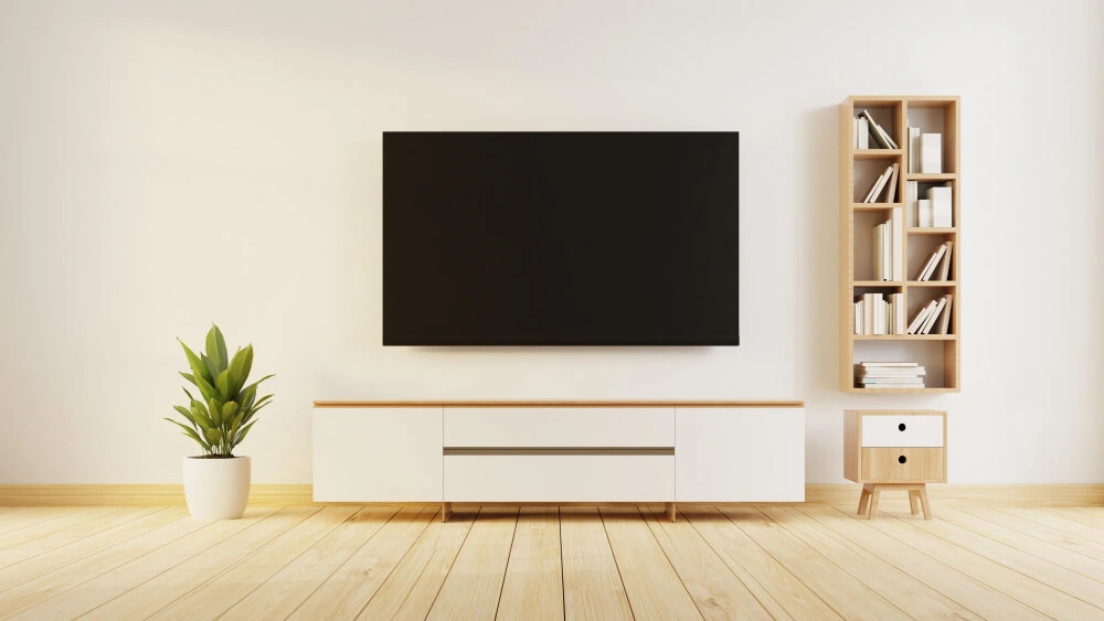 A minimalist media setup with a white floating TV console, a wall-mounted TV, and a light wood shelf.